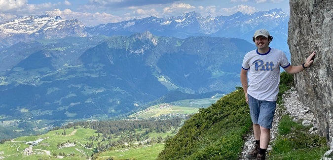 Student posing with mountains in the background