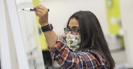 Student writes on a white board