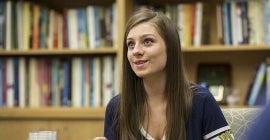 A student in front of a bookcase