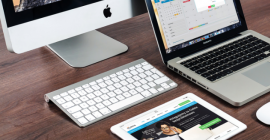 Laptop, ipad, and desktop computer on table 