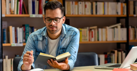 Student Reading a Book in Library